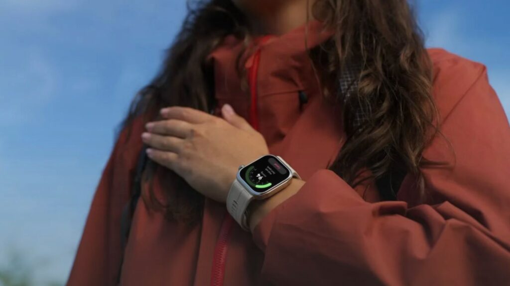 Persona al aire libre usando el smartwatch HUAWEI WATCH D3 de color dorado mientras revisa sus métricas de salud en pantalla.